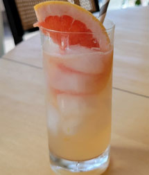 Citrus Lavender Spritz in a glass with ice and grapefruit garnish