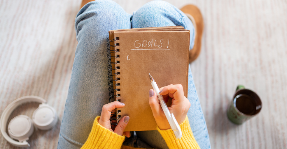 Person sitting with a notebook with a list of goals written out