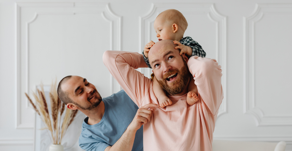 Two men, one with a baby on his shoulders.