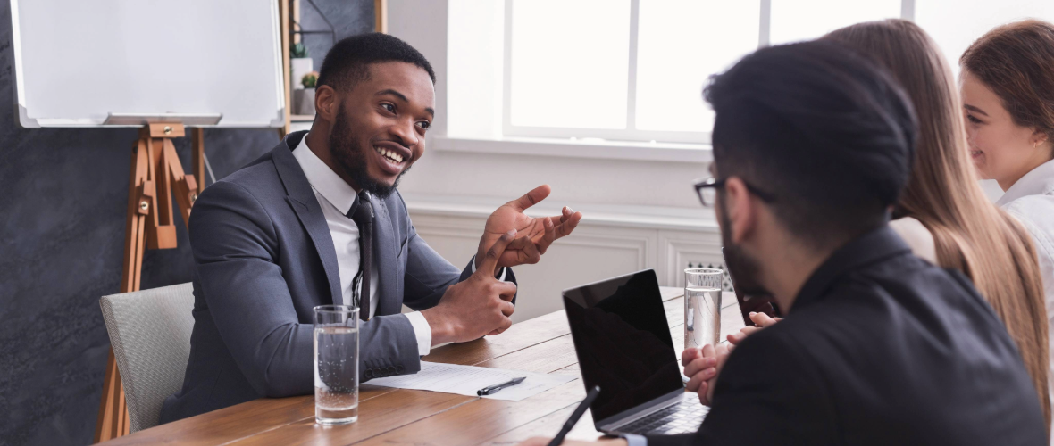 Man being interviewed by three people in a conference room.