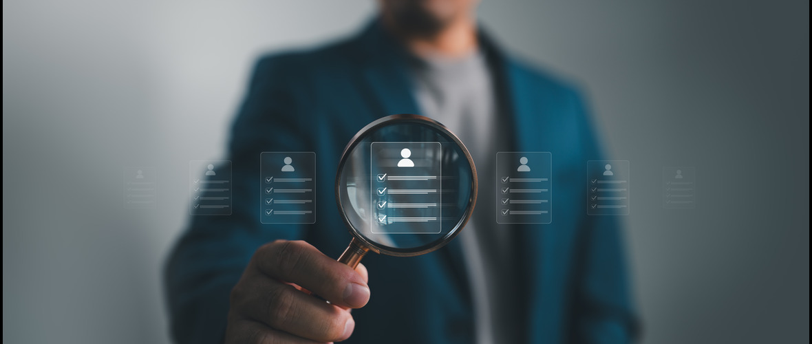 Man holding magnifying glass over digital profile icons with checklists.