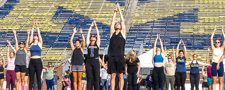 people doing yoga on Michigan Stadium's field