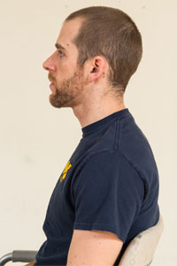 Photo of a man sitting so he is facing to the left