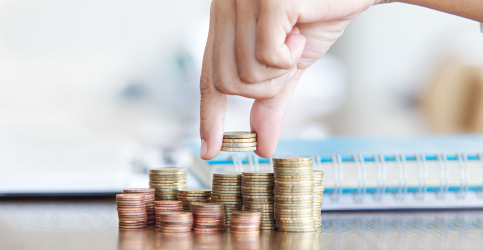 A white hand with fingers stacking columns of silver coins