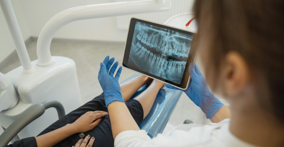 Person sitting in dental chair reviewing their dental x-rays