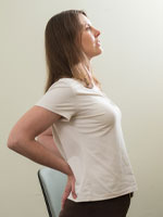 woman standing with hands on the back of her hips leaning back