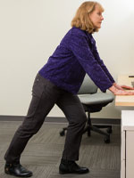Woman leaning of table with leg stretched back