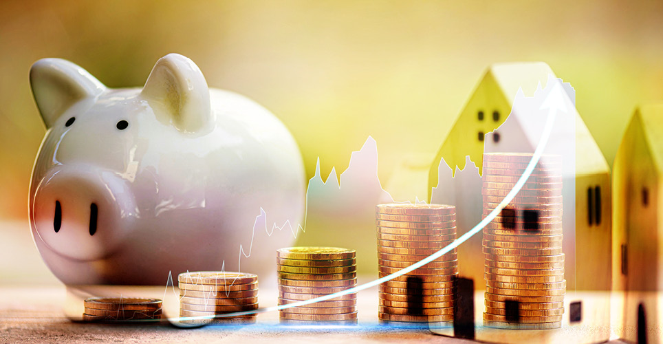 piggy bank surrounded by coins and a model house