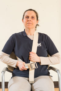 photo of woman sitting in a chair with a belt around her neck and side