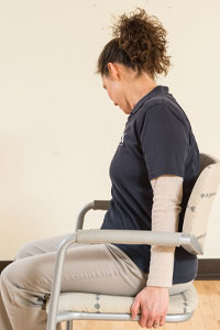 photo of woman sitting facing the left with neck bent down to the side