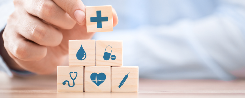 Person placing blocks with health care symbols on top of one another.