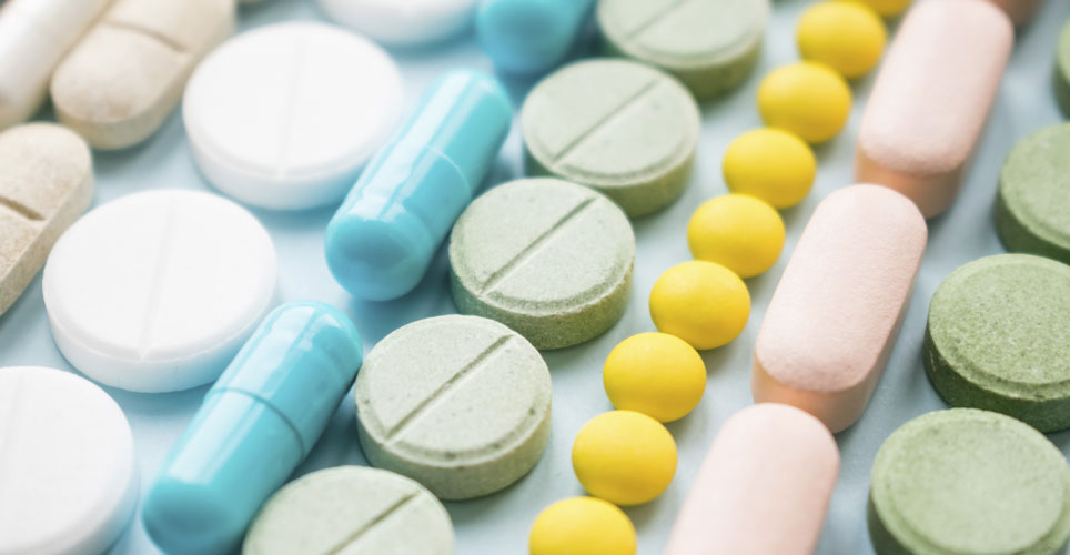 rows of circular and rectangular pills and tablets of different colors