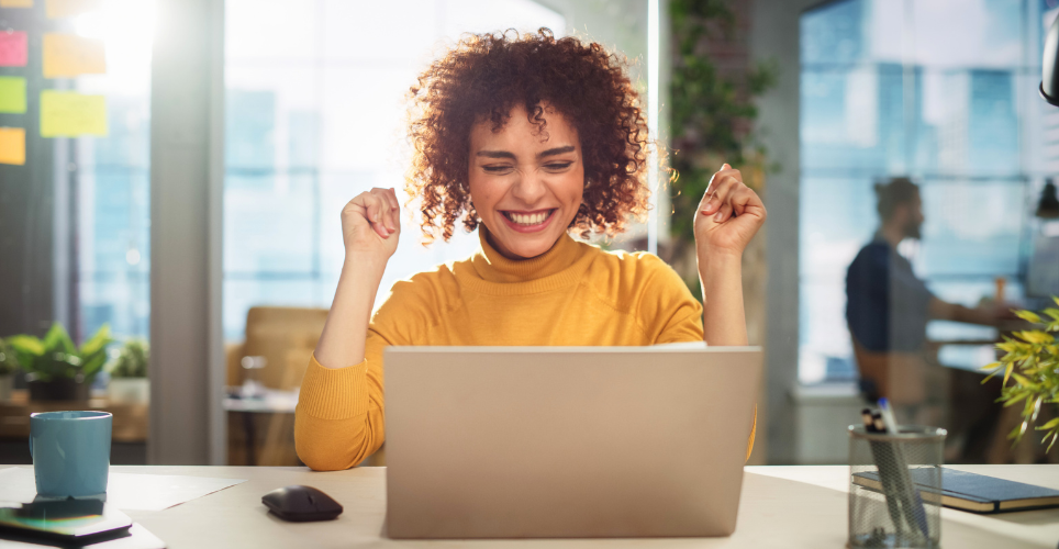 Woman sitting at her desk in excitement
