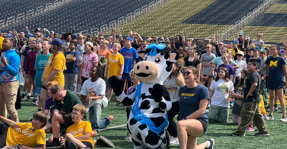 students on the field of Michigan Stadium