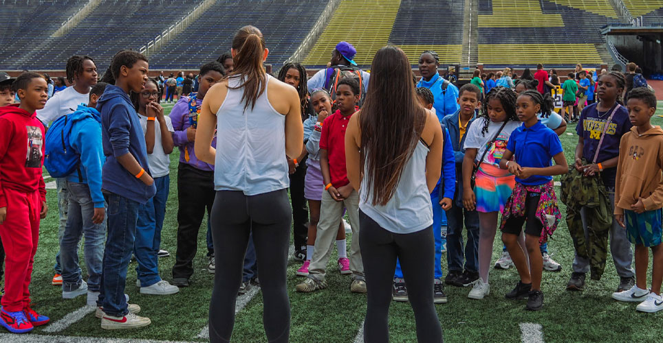 students on the field at Michigan Stadium