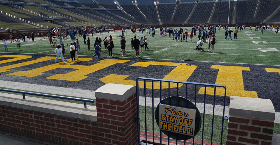 students on the field at Michigan Stadium