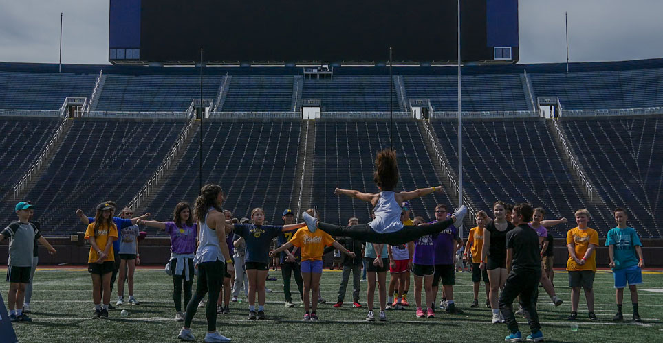students on the field at Michigan Stadium