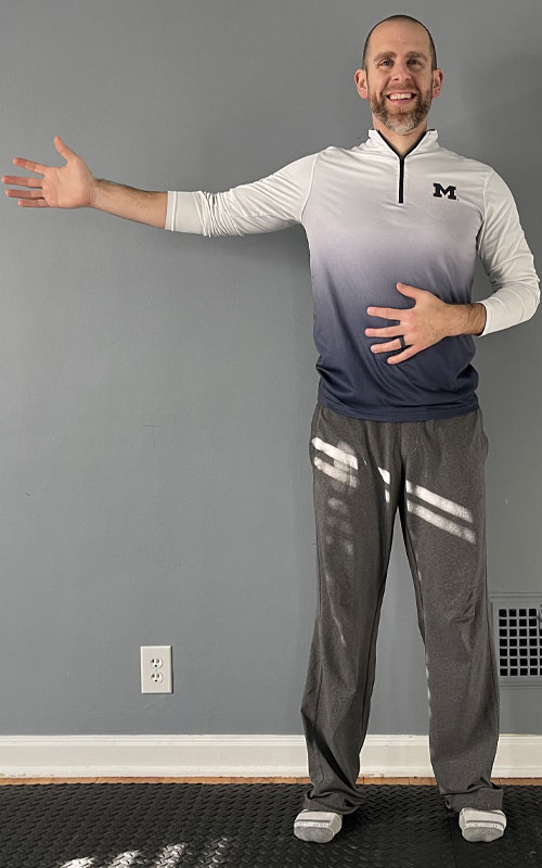 man standing with one arm stretched to the side