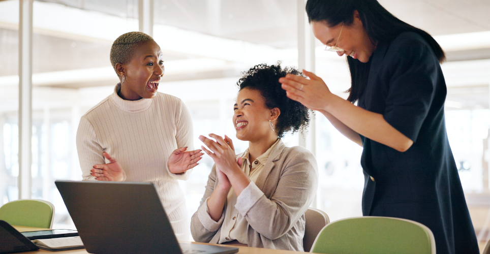 Coworkers cheering together in a positive workplace