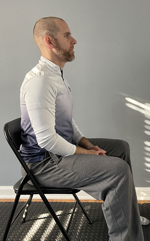 man sitting in chair with feet on the ground
