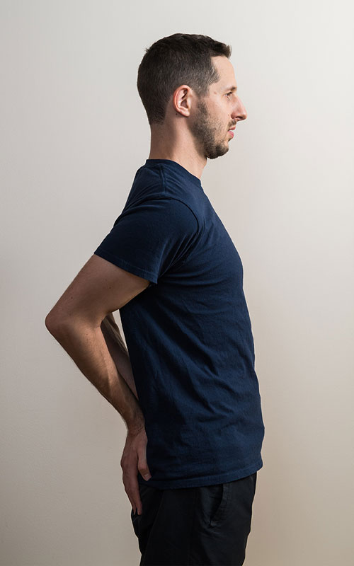 Young man standing showing standing arch extension start movement