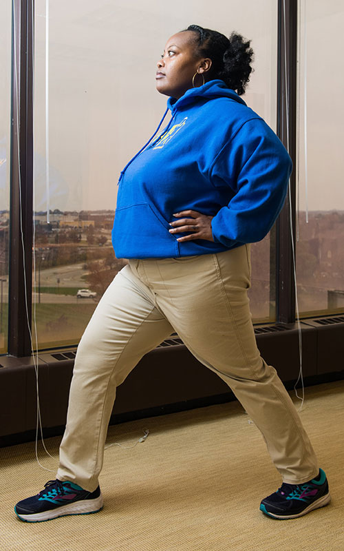 Young woman standing showing standing hip flexor stretch start movement