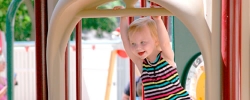 Young girl playing on the slide of a playground outside