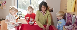 Teacher and toddlers playing with water indoors