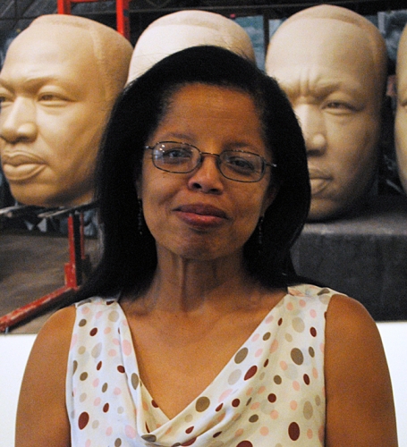 Addell Anderson in front of statues of heads