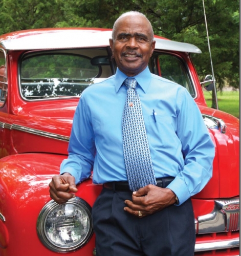 Jimmy Crudup standing in front of red Ford truck