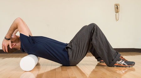 man laying on a foam roller