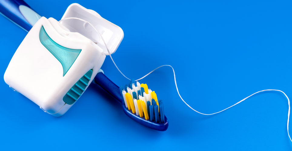 A dark blue toothbrush with white dental floss