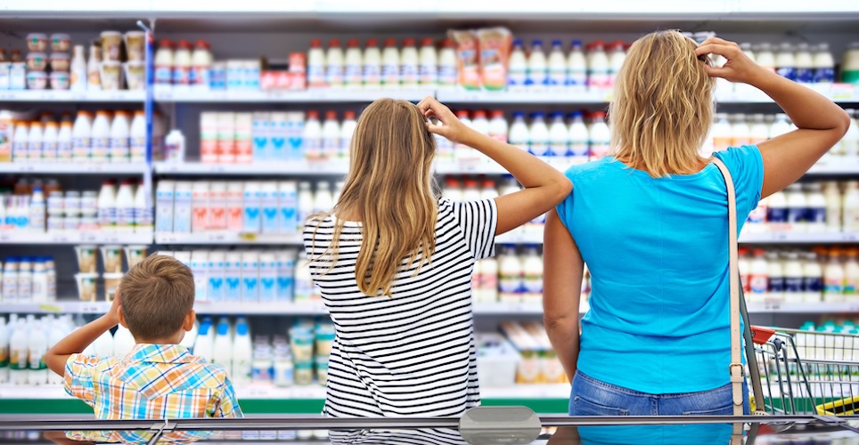 mother and two children facing a store shelf all scratching their heads in confusion
