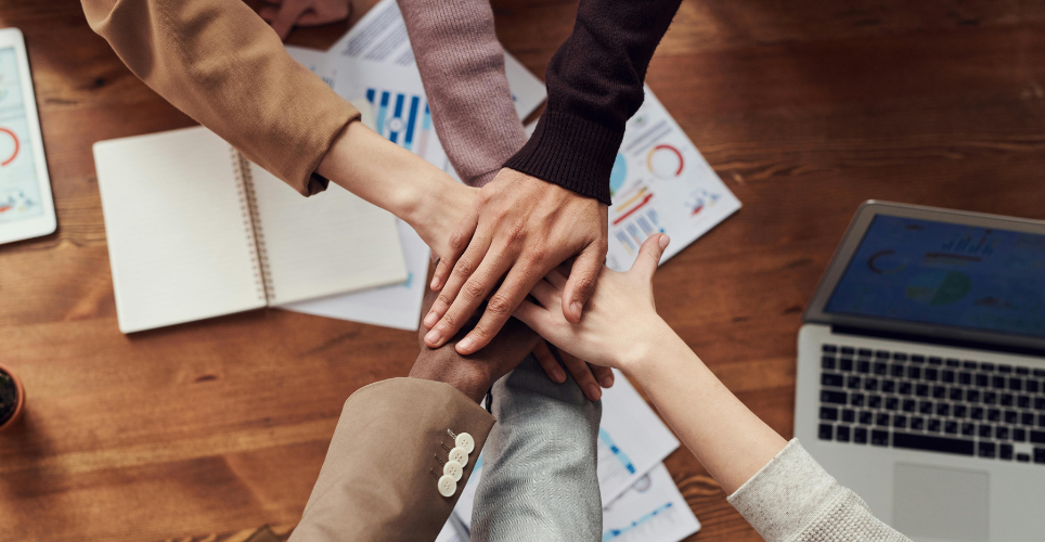 Team members stacking their hands together.