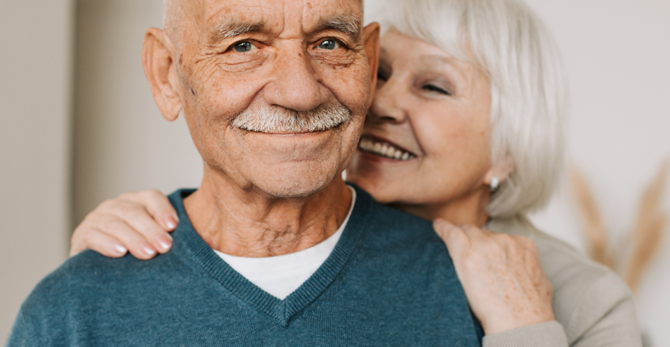 Older couple smiling at camera and embracing