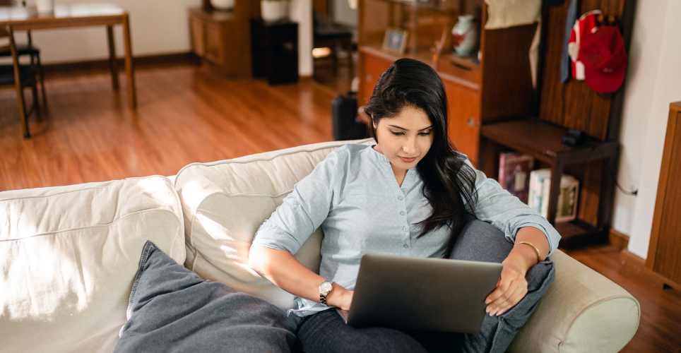 Woman sitting on couch using her laptop.