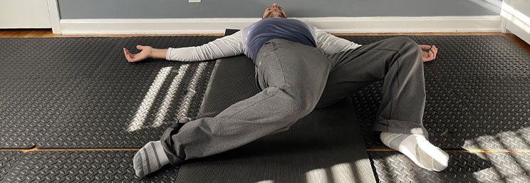 man laying on floor with knees bent to the side